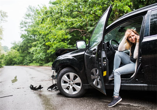 A driver calling for help next to a crashed car, illustrating the confusion and stress of determining fault after an L3 autonomous driving accident.
