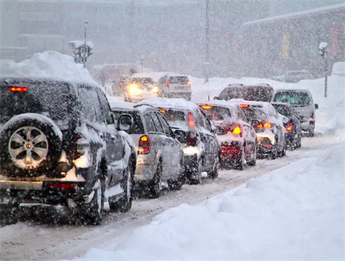 Traffic jam on a snow-covered urban road, illustrating the challenges of winter weather for driver assistance features