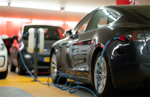 Multiple EVs charging in an underground parking garage, illustrating the market context for EV value shifts with new battery tech.